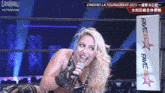 a woman is singing into a microphone in a ring .