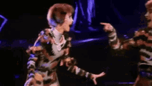 two women are dancing on a stage in a musical .