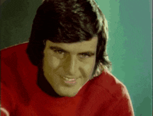 a man wearing a red sweater with a coca cola logo on it