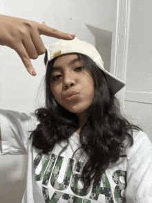 a girl wearing a hat and a t-shirt that says uiuas