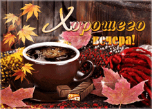 a cup of coffee sits on a saucer next to a chocolate bar and leaves