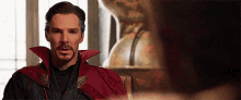 a man in a red cape is sitting in a chair .