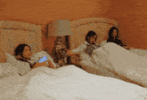a woman laying on a bed holding a blue cell phone