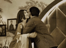 a black and white photo of a man and woman hugging and kissing