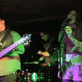 a man playing a guitar and a woman singing on stage