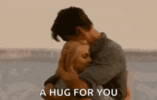 a man and woman hugging each other with the words `` a hug for you '' written on the bottom .