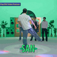 a man in a white shirt is dancing in front of a sign that says san