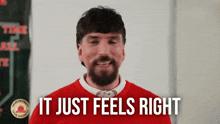 a man in a red sweater with the words it just feels right above him