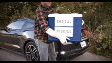 a man carrying a blue cooler that says drill press
