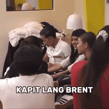 a group of people are sitting in a room with the caption kapit lang brent