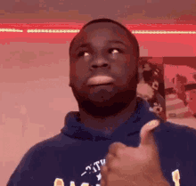 a man with a beard is giving a thumbs up sign .