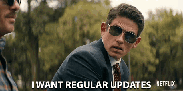 a man wearing sunglasses and a suit says