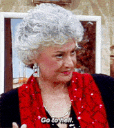 a woman with gray hair and a red scarf says " go to hell "