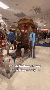 a woman is standing next to a statue of a witch in a store with the caption " the definition of my soul left my body "