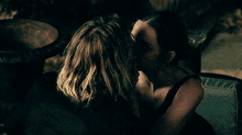 a man and a woman are kissing in a dark room