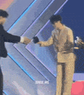a man in a suit is shaking hands with another man in a suit
