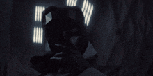 a man in a dark room is looking at the camera