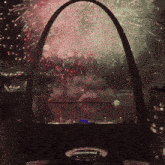 a fireworks display is being watched from the arch