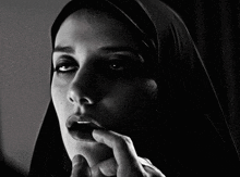 a black and white photo of a woman wearing a veil