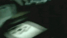 a blurred image of a person 's face in a dark room .