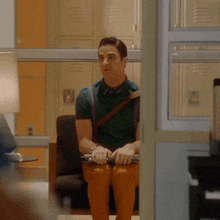 a man in suspenders sits in a chair