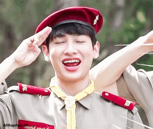 a man in a military uniform salutes with the word atthaphan written on the bottom