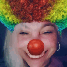a woman is wearing a clown wig and red nose