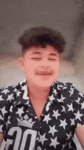 a young boy wearing a black and white shirt with stars and the number 20 on it