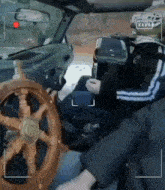 a man is sitting in a car with a wooden steering wheel and a helmet on .