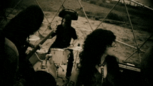a man in a pirate hat is playing drums in a black and white photo