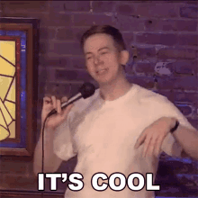 a man is singing into a microphone and says it 's cool .