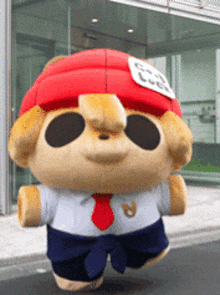 a stuffed animal wearing a red hat and tie says good luck on it