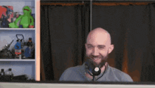 a bald man with a beard is wearing a headset