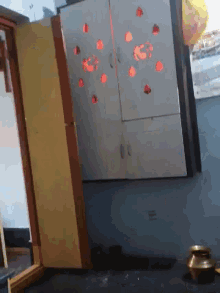 a corner of a room with a yellow cabinet and a white cabinet with red hearts on it