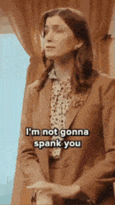 a woman in a suit is saying i 'm not gonna spank you .