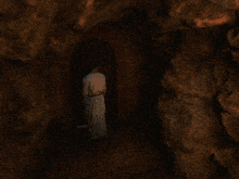 a man in a white shirt with a black belt around his waist is standing in a dark room