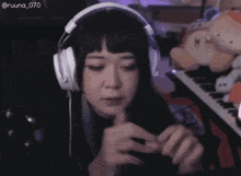 a woman wearing headphones with the hashtag @ruuna_070 on the bottom