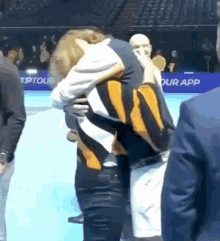 a man is hugging another man in front of a sign that says our app