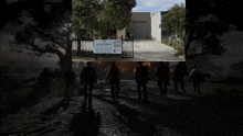 a group of people are walking in front of a workshop 24 sign