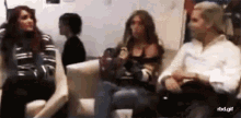 a group of people are sitting on a couch in a room .