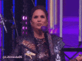 a woman in a leather jacket singing into a microphone