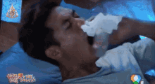 a man is laying on a bed with a tv screen behind him that says ' courage '