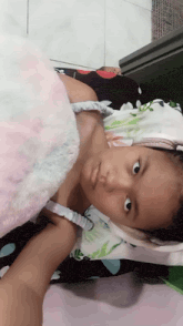 a little girl laying on a bed with a blanket