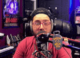 a man wearing headphones and glasses is in front of a microphone with a police badge on it