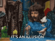 a man in a blue sweater says it 's an illusion next to a kermit the frog