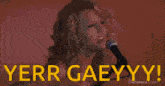 a woman singing into a microphone with the words yerr gaeyyy written on the bottom