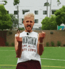 a man wearing a shirt that says wntown any cows on it