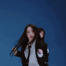 a woman wearing a suit and tie is dancing
