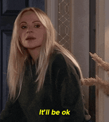 a blonde woman says it 'll be ok while standing in front of a blue door