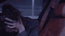a close up of a person sitting in a car using a computer .